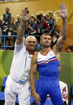Russia's Alexei Nemov, right, acknowledges the crowd as they protest Nemov's score on the apparatus after completing his high bar routine during the men's gymnastics individual apparatus finals at the 2004 Summer Olympic Games in Athens, Monday, Aug. 23, 2004.